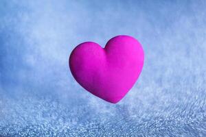 volumetric violet red heart on a blue background of sparkles photo