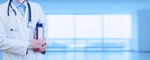 Wide background of doctor's business card. Medical education. A student holds books under his arm. faceless promotional banner. photo