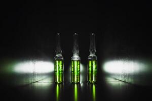 green ampoules on a black background. Narcotic acid. low key photo