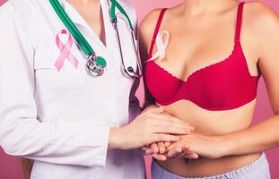 The concept of breast cancer the doctor holds the patient's hand as a sign of support in the fight against cancer. Pink Ribbon photo