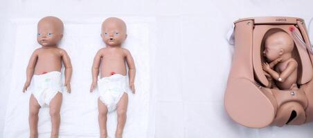 A set of children's dummies for doctors. Mother of the mother's maternity head, practical research and preliminary treatment. Medetsinskaya doll of a newborn lung disease. background photo