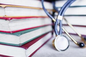 Medical student multicolor textbook and stethoscope. Collection of scientific papers photo