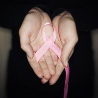 Pink ribbon for breast cancer awareness, symbolic bow color raising awareness on people living with women's breast tumor illness. photo