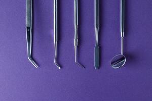 Dental tools on violet background photo