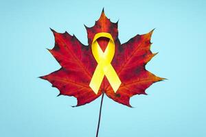 childhood cancer awareness day. Yellow ribbon on blue background. photo