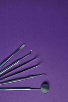 Dental tools on violet background photo