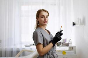 Portrait of a cosmetologist in the office with a syringe. Injection procedure for lip augmentation. Advertising concept for facial care, youth and beauty. photo