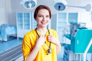 hermosa niña médico sonriente. brillante retrato. concepto de el médico antecedentes en amarillo formar en el operando habitación. foto