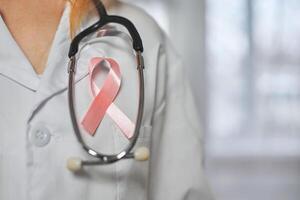 Pink cancer awareness ribbon on doctor's coat. World Cancer Day photo