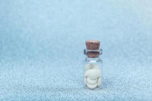 médico farmacéutico antecedentes con blanco pastillas en un vaso botella. farmacia fármaco para salud. píldora de felicidad. foto