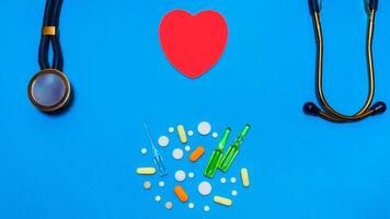 clasificado farmacéutico medicina pastillas, tabletas y cápsulas rojo corazón con estetoscopio foto
