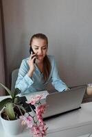 A young woman undergoes remote training while sitting at a table in the living room. photo