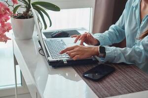 Happy beautiful woman working on a laptop Cozy workplace, remote work, e-learning concept photo