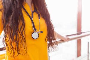 doctor beautiful girl in yellow uniform with stethoscope. Health care. background photo