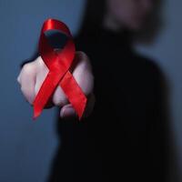 healthcare and medicine concept. Aids Awareness. red AIDS awareness ribbon on black background fist fight. copyspace for your individual text. photo