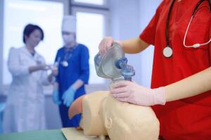 grupo de médico trabajadores el concepto de el práctica de artificial respiración por un joven doctor. forzado oxígeno entrega a el del paciente livianos por un enfermero. cpr antecedentes foto