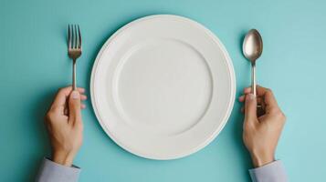 AI generated man putting empty plate with fork and spoon on blue table photo