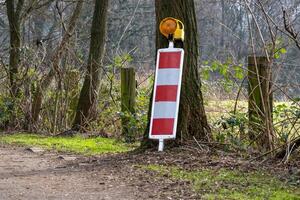 red and white warning sign with warning light photo