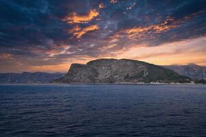 Westcap in Norway. Mountain that reaches into the fjord. Cloudy sky with clouds photo