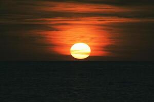 Sunset over the Baltic Sea. The red sun sinks into the sea. Evening atmosphere photo