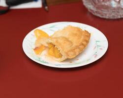 the first piece of a delicious peach pie photo