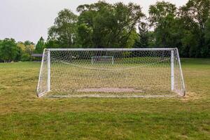 temprano Mañana ver de un juventud fútbol campo en un ciudad parque foto