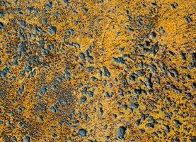 Muchos agujeros escarpados en el piso de concreto de color oxidado foto