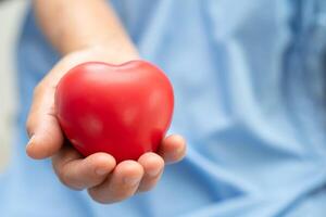 Doctor holding a red heart in hospital, healthy strong medical concept. photo