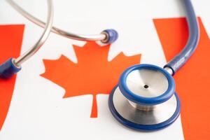 Stethoscope on Canada flag background, Business and finance concept. photo
