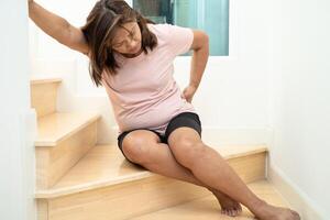 Asian lady fall down the stairs and pain at hip and waist because slippery surfaces. photo