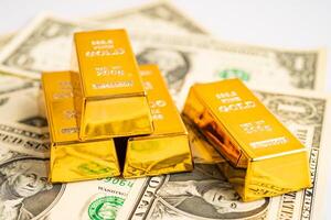 Gold bar on US dollar banknotes money and graph, economy finance exchange trade investment concept. photo