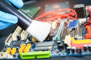 asiático técnico reparar y limpieza sucio micro circuito principal tablero de teléfono inteligente electrónico tecnología con cepillar, hardware, móvil teléfono, potenciar concepto. foto