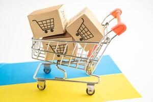 Box with shopping online cart logo and Ukraine flag, Import Export Shopping online or commerce finance delivery service store product shipping, trade, supplier. photo