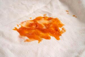 Dirty tomato sauce stain or ketchup on cloth to wash with washing powder, cleaning housework concept. photo