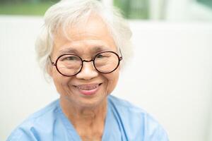 asiático mayor mujer vistiendo los anteojos o visión lentes a hogar cuidado servicio. foto