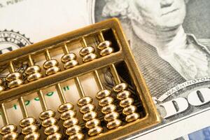 Gold abacus on USA dollar banknote money, economy finance exchange trade investment concept. photo