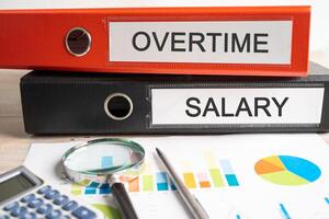 Overtime salary, Binder data finance report business with graph analysis in office. photo
