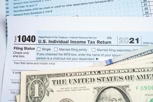 Tax Return form 1040 and dollar banknote, U.S. Individual Income. photo