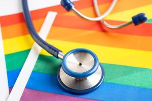 Stethoscope on rainbow flag background, symbol of LGBT pride month celebrate annual in June social, symbol of gay, lesbian, bisexual, transgender, human rights and peace. photo