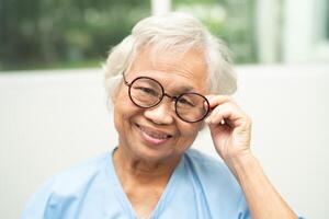 Asian senior woman wearing eyeglasses or vision glasses at home care service. photo