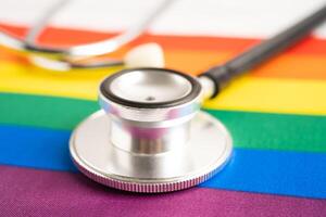 Black stethoscope on rainbow flag with heart, symbol of LGBT pride month celebrate annual in June social, symbol of gay, lesbian, bisexual, transgender, human rights and peace. photo