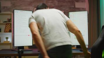 joven hombre preparando para un en línea tirador juego sesión. concentrado jugador viniendo a su escritorio video