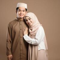 AI generated Heartwarming portrayal of a young Asian Muslim couple in traditional attire, including hijab, exchanging joyful Eid Mubarak gestures in a studio setting with a neutral color palette photo