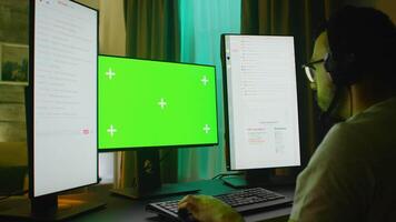 Concentrated young man playing games on powerful PC with green screen in a room with neon light. video