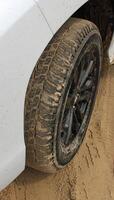 Car wheel on a sandy road with tire packed  with sand photo