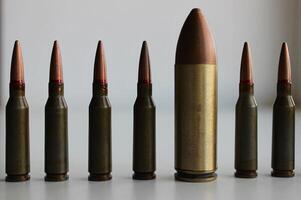 Closeup View Of A Row With Same Ammunition And Huge Cartridge In Line. Concept Image Symbolizing Diversity And Inclusion photo