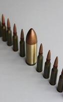 Inclusion And Diversity. Row of same bullets with one big bullet lined out isolated on white photo