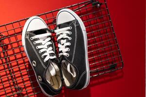 Black sneakers on red background. Pair of Black White Sneakers. photo