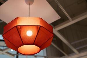 Red lamp shade. Hanging Lamp with Red Shade, Modern Chandelier with Light Bulb. photo