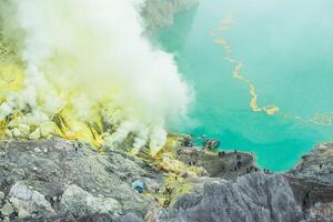 The acid lake and Sulfur fumes from the crater of Kawah Ijen Volcano in Java island of Indonesia. photo